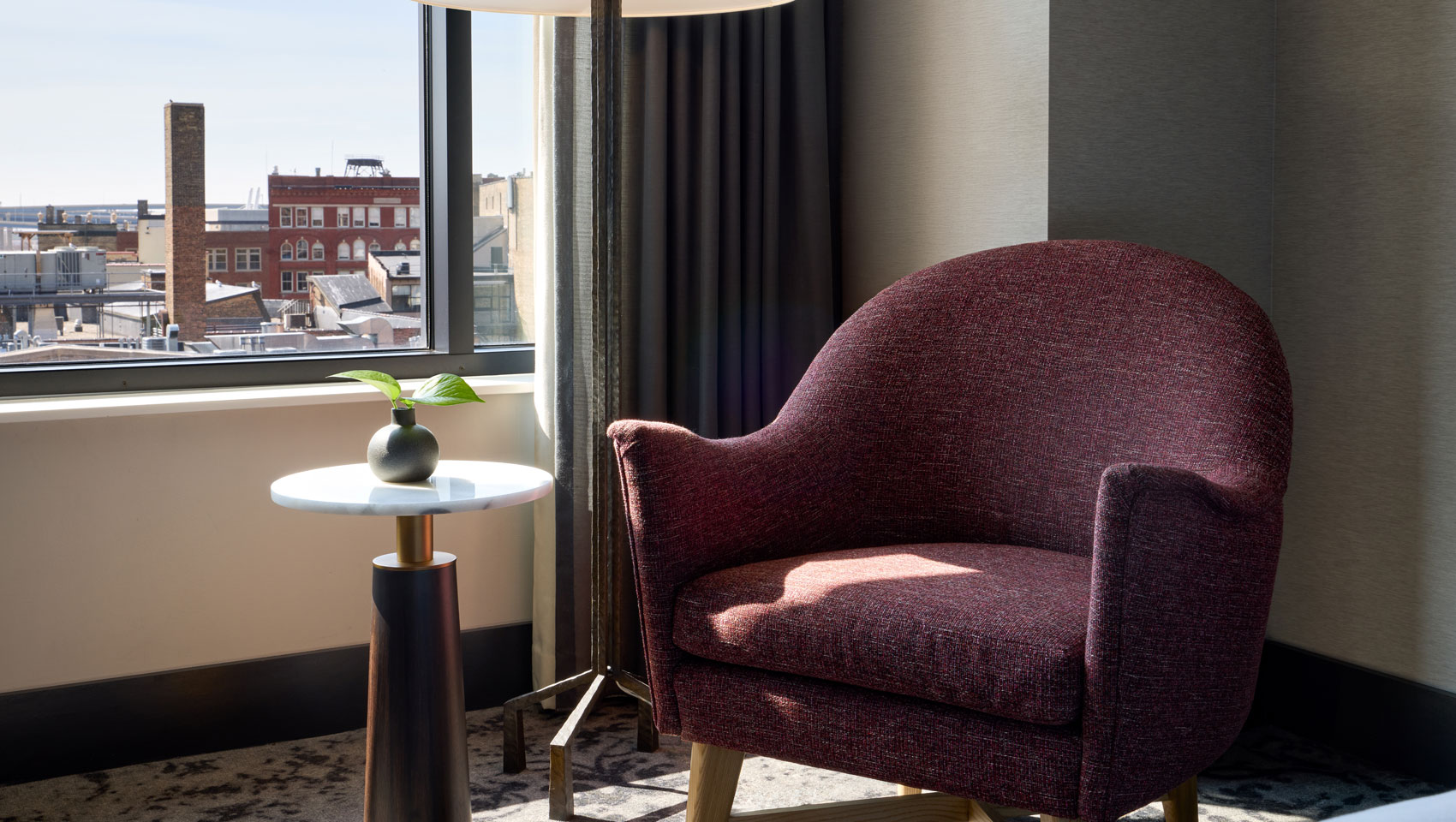 Chair, table and lamp in guestroom at Kimpton Journeyman Hotel